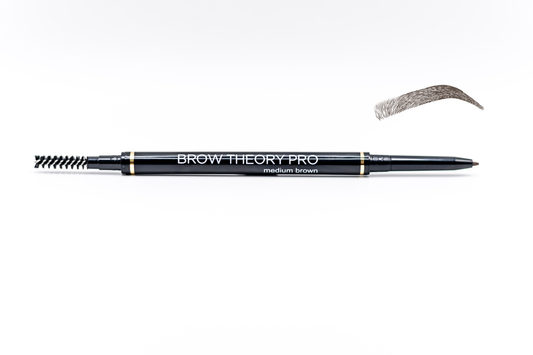 A dual-ended eyebrow pencil with a spoolie side and an eyebrow drawing side, shown on a white background with a sample eyebrow swatch above it. The pencil is black with gold accents and white text reading 'BROW THEORY PRO' and 'medium brown'.
